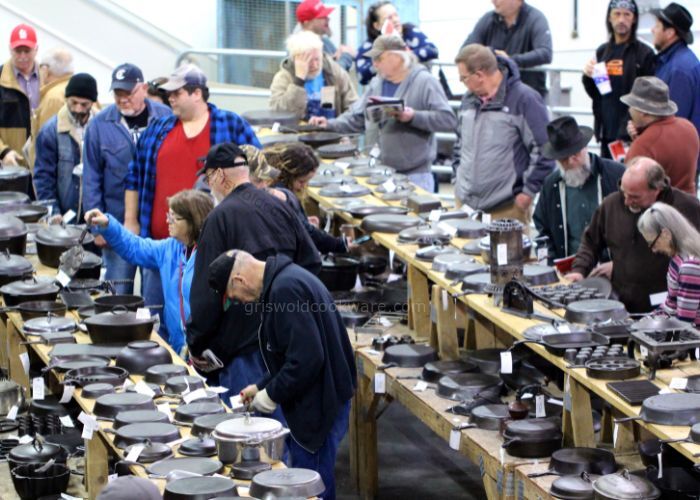 Potential bidders preview many pieces of antique and vintage cast iron cookware before the auction starts. 