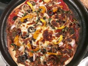 Homemade pizza on a cast iron round griddle. 