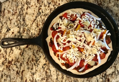 Cast iron griddle with homemade pizza. 