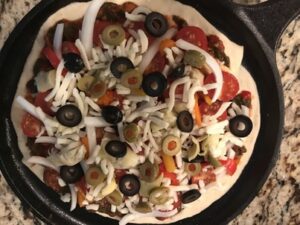 Homemade pizza on a cast iron round griddle. 