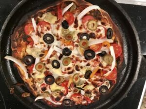 Homemade pizza on a cast iron round griddle. 