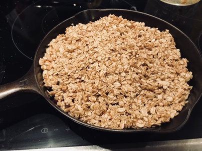 Oat topping for strawberry crumble on the stove in a vintage Griswold number 6 cast iron skillet pan. 