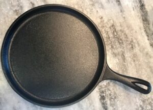 Top of round Lodge cast iron griddle with handle. 