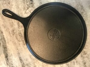Bottom of round Lodge cast iron griddle with handle. 