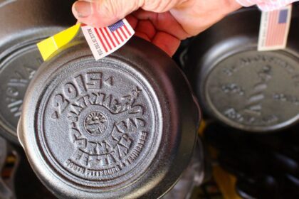 Vintage Cast Iron collector Harold Henry holding a 2015 Cornbread Festival Lodge commemorative skillet.