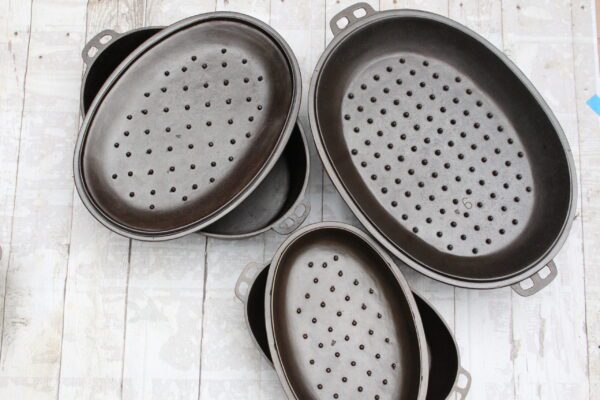 three vintage unmarked Lodge cast iron oval roasters with trivets sizes 4 7 9 collection of John Clough