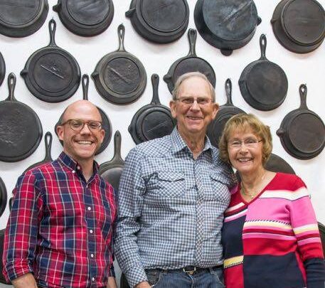 Josh Miller Larry and Marg O'Neil in front of a Wall of Antique Gatemarked Cast Iron Skillets
