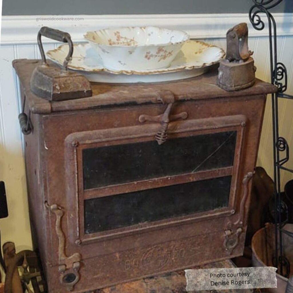 Antique Griswold BOLO oven with two sad irons on top. 