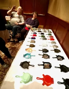 Dave and Nancy Lange with Dave's collection of vintage and antique cast iron Griswold ashtrays at cast iron convention. 