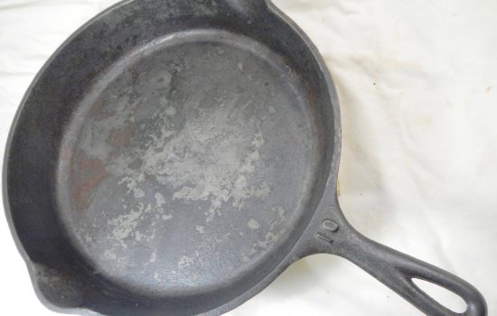 Vintage cast iron pan with flaking and fire damage