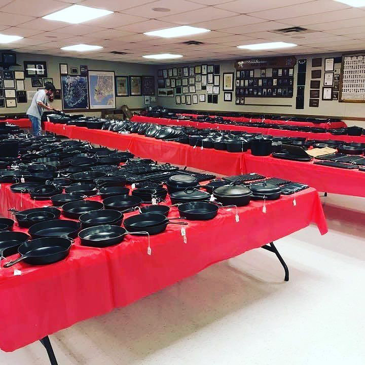 Rows upon rows of cast iron set out on tables for inspection prior to the large vintage and antique cast iron cookware auction begins. 