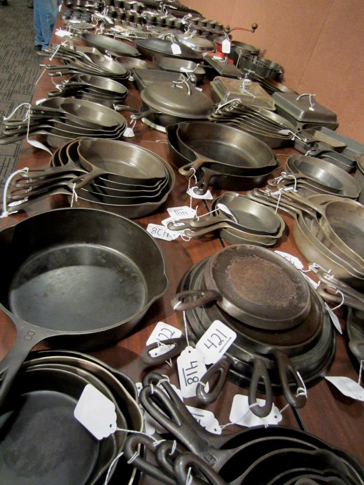 Piles of vintage and antique cast iron cookware awaiting inspection at a large cast iron cookware auction. 