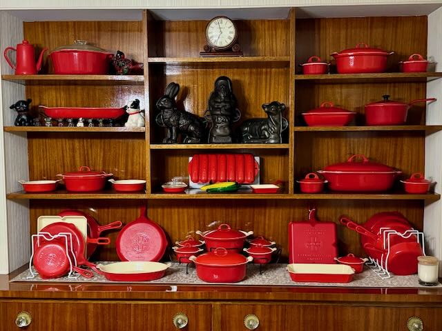 Display of vintage cast iron: Griswold Flamingo red cast iron, lamb, rabbit and Santa mold, Fido Hubley dogs, and small cast iron pups. 