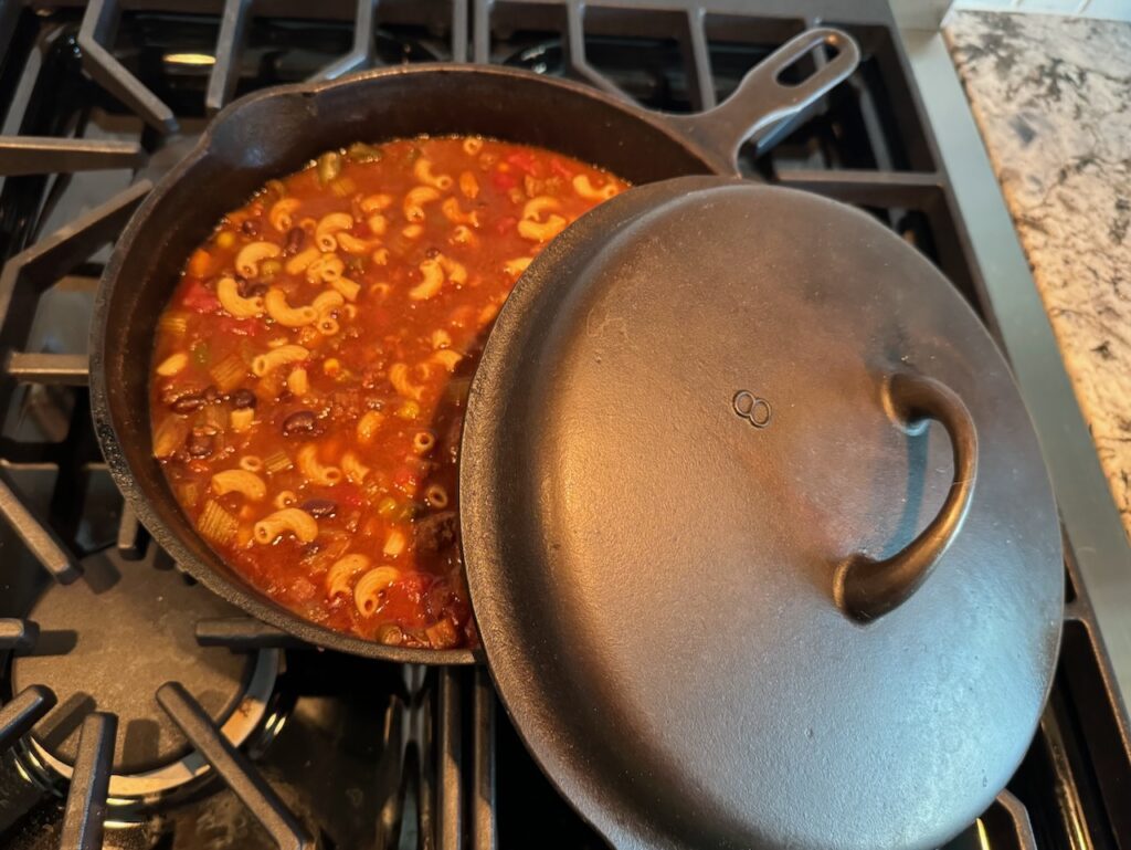 Chili cooking on the stove in my vintage cast iron Iron Mountain (by Griswold) chicken pan. Lid also shown. 