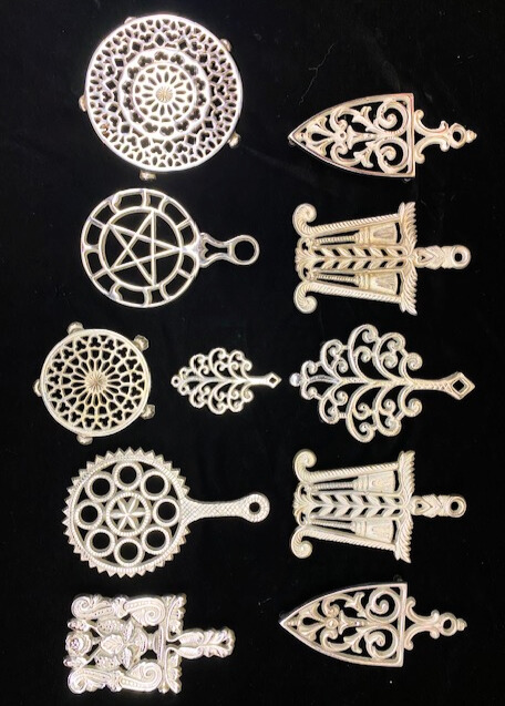 11 vintage plated Griswold cast iron trivets. 