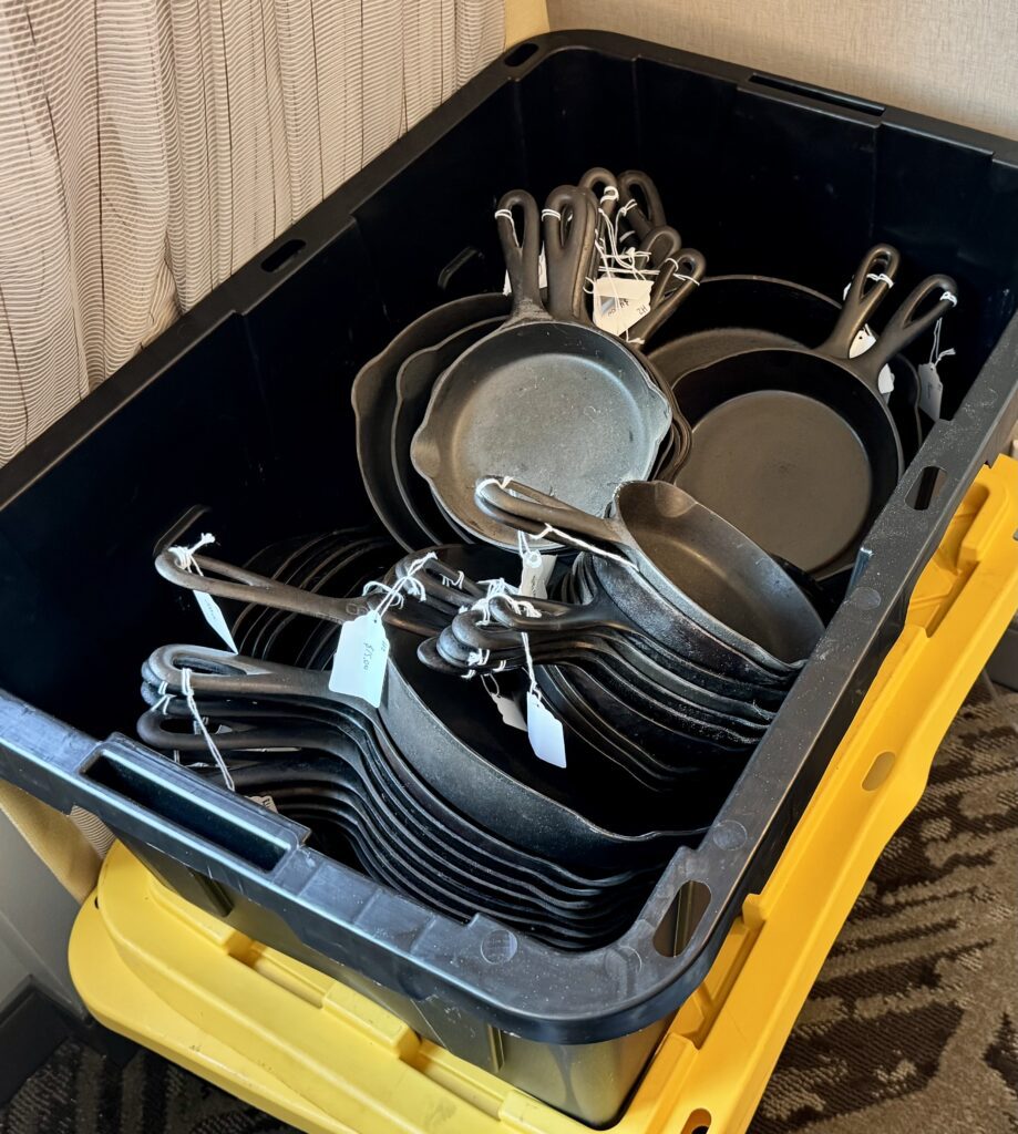 Tote with many cast iron skillets.