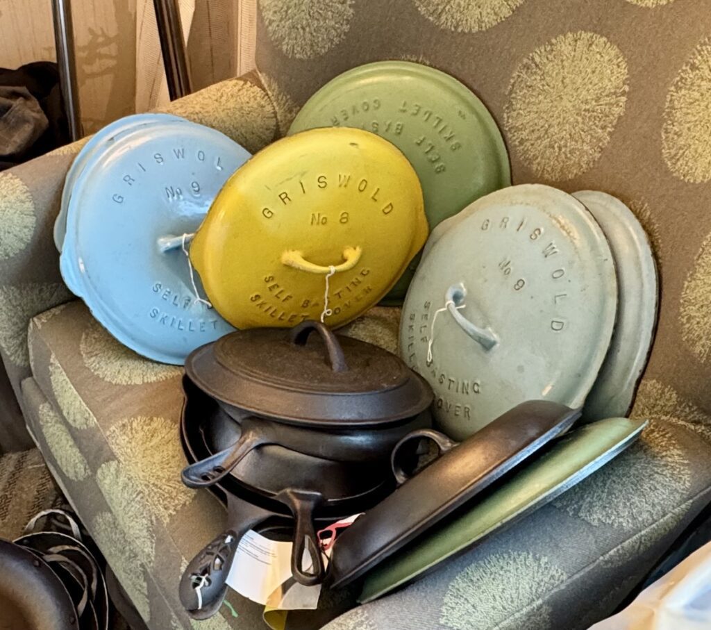 Colorful cast iron skillet lids on a chair in a room at the cast iron convention. 
